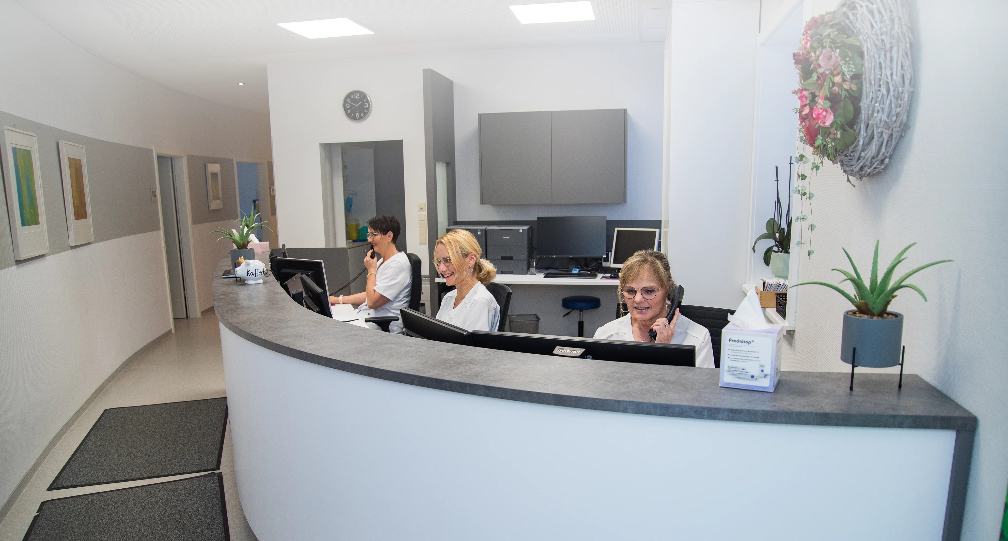 Der Empfangstresen in der Praxis mit drei Mitarbeiterinnen