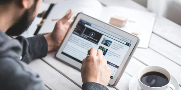 Blick über die Schulter einer Person mit einem Tablet