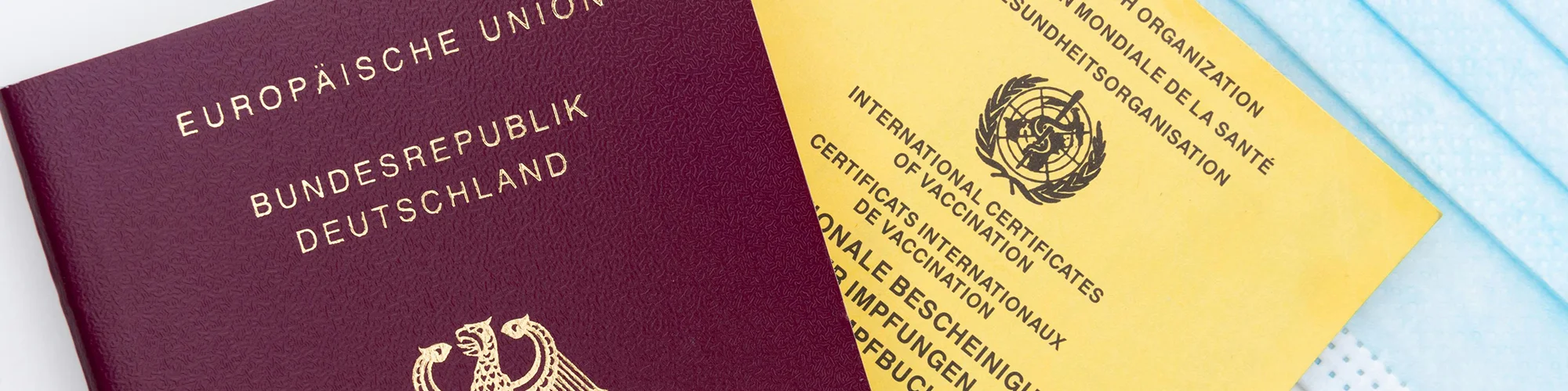 Detailaufnahme eine Reisepass und einem Impfpass daneben liegend
